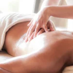 Hands applying essential oil to skin during a therapeutic massage