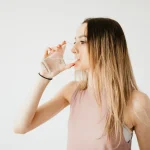 Glas mit Eiswasser neben einem Teller mit Essen auf dem Tisch