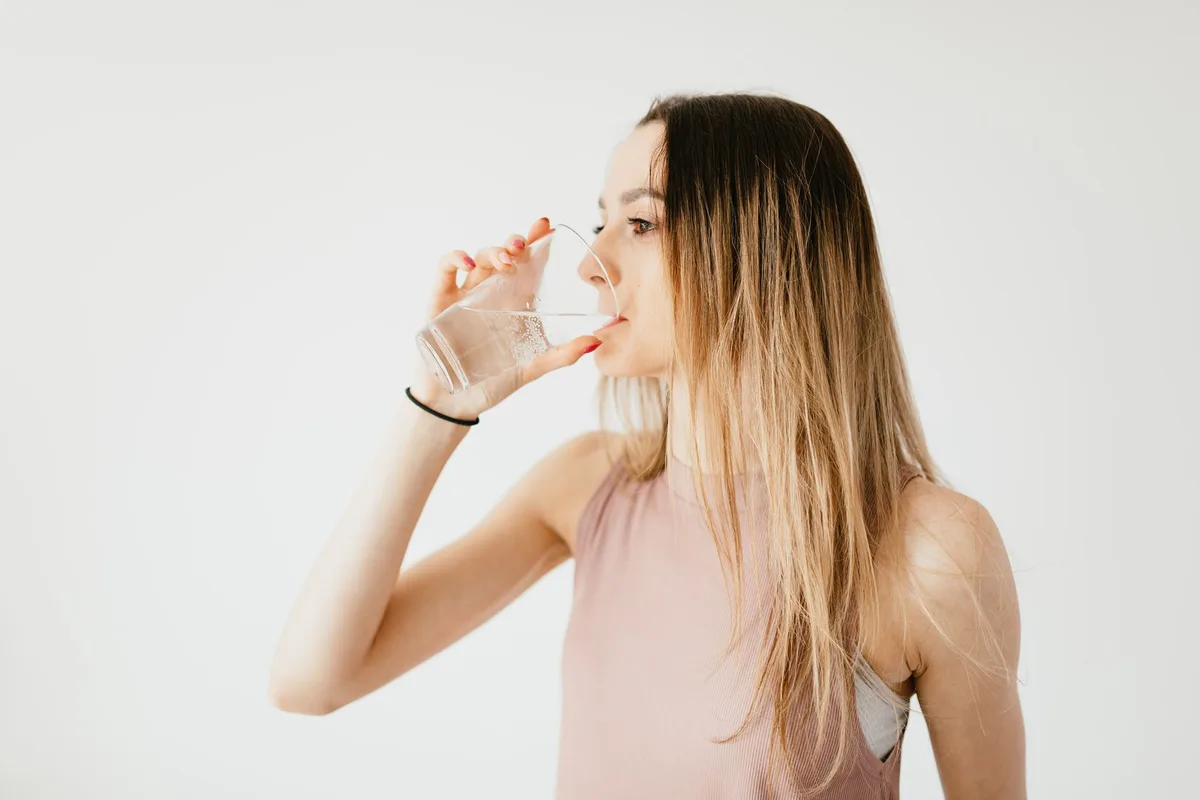 Glas mit Eiswasser neben einem Teller mit Essen auf dem Tisch