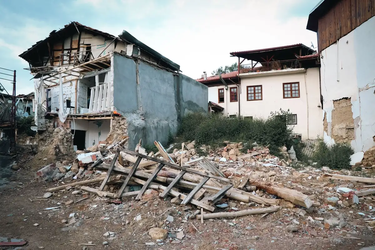 Ruins of collapsed buildings and ongoing reconstruction work in a devastated town center