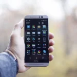 Person holding a smartphone with a sportsbook betting app displayed on screen