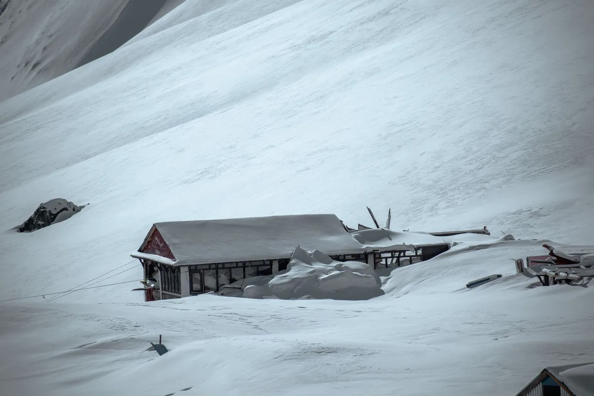 Snowy mountain landscape showing avalanche danger zones and rescue operations on high-altitude peaks