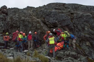 Rescue team members in winter gear navigating snow-covered mountain slopes during a high-altitude search operation
