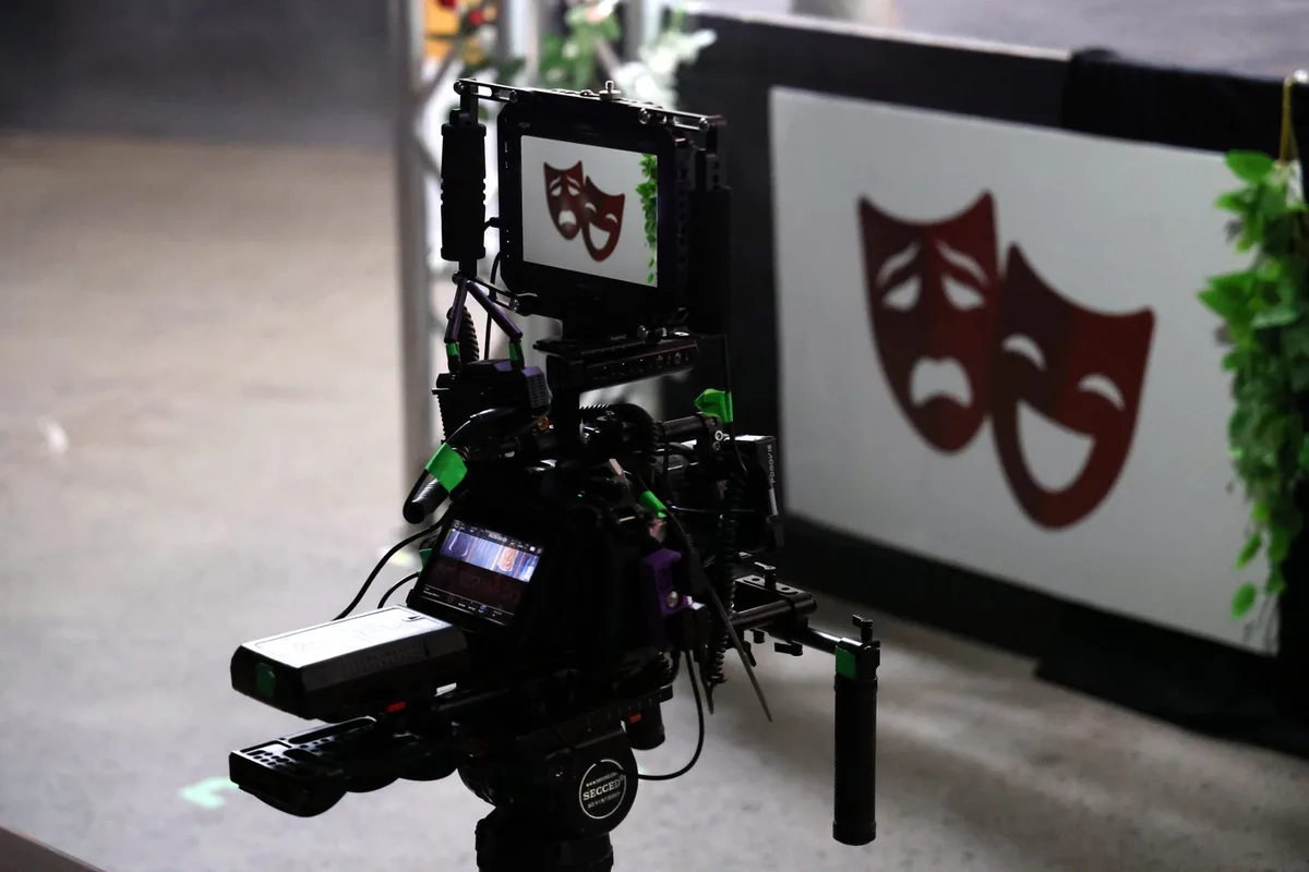Professional film camera setup recording a live theater performance on stage
