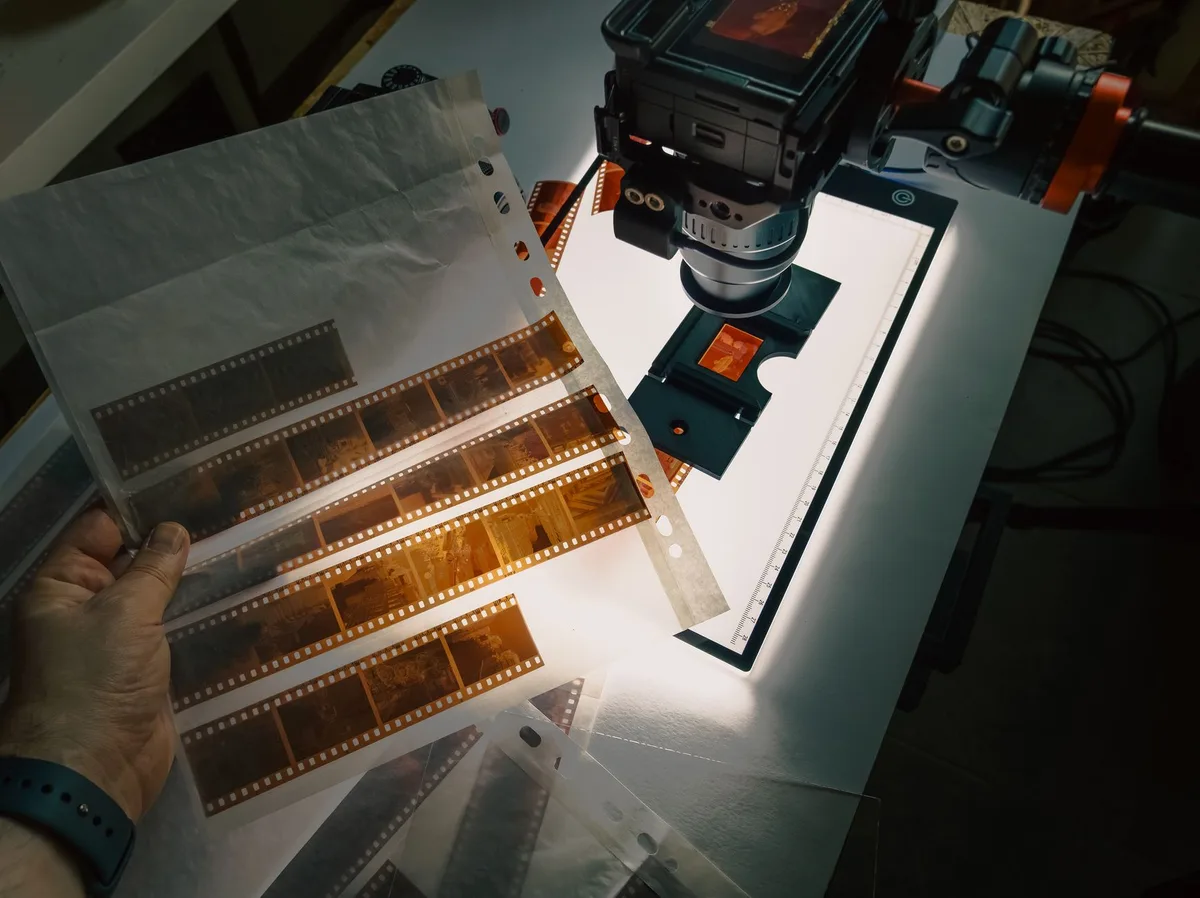 Technician examining film restoration process on high-resolution scanner