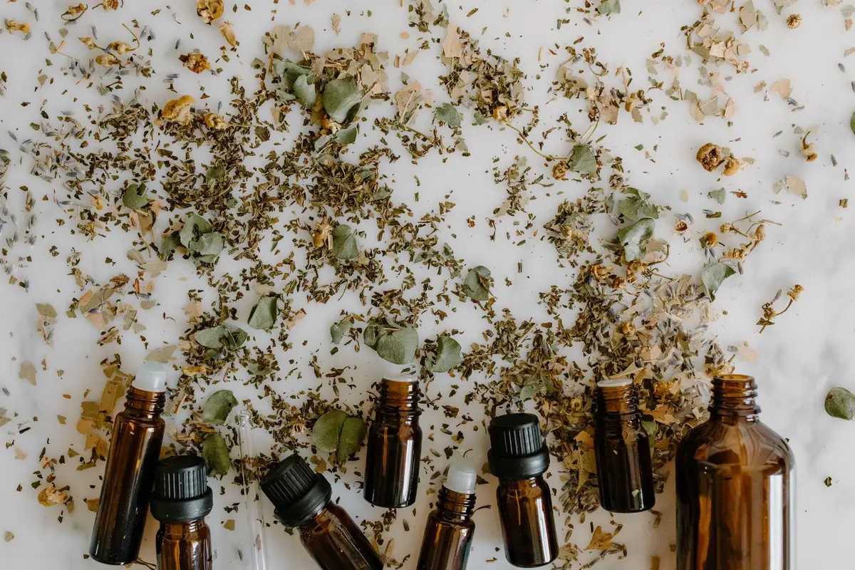 Collection of essential oil bottles with lavender, peppermint, and chamomile herbs