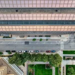 Modern cityscape with green spaces, pedestrian pathways, and sustainable urban infrastructure integrated throughout the