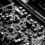 Macro photograph of an integrated circuit chip on a printed circuit board with visible traces and solder points