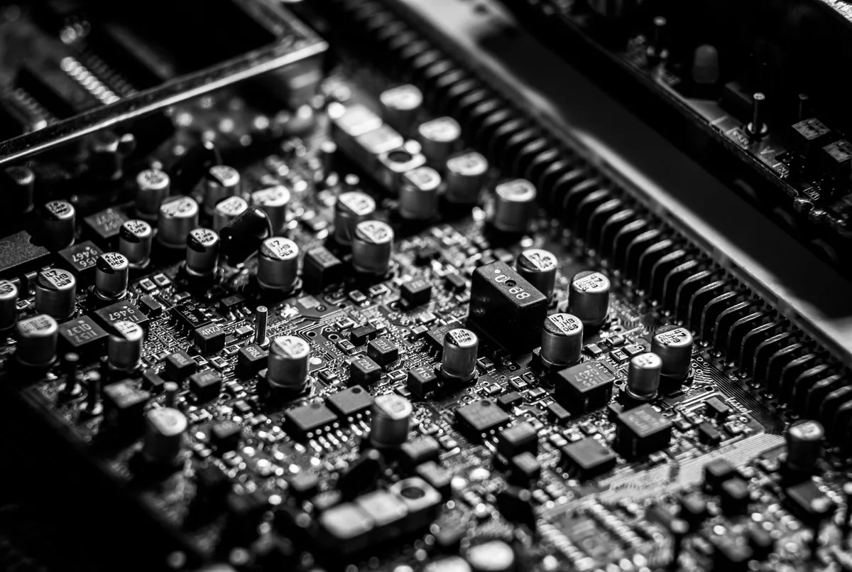 Macro photograph of an integrated circuit chip on a printed circuit board with visible traces and solder points