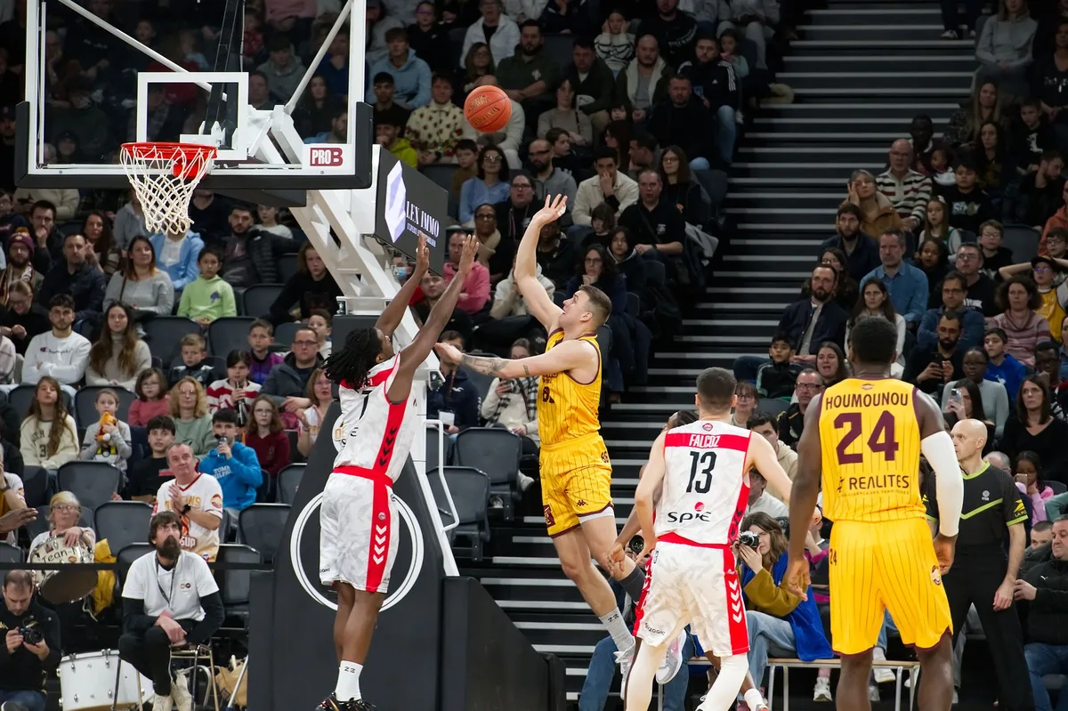 Basketball player shooting during a game with defenders nearby