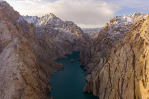 Tourists hiking through mountainous terrain with turquoise lakes and red cliffs in Afghanistan