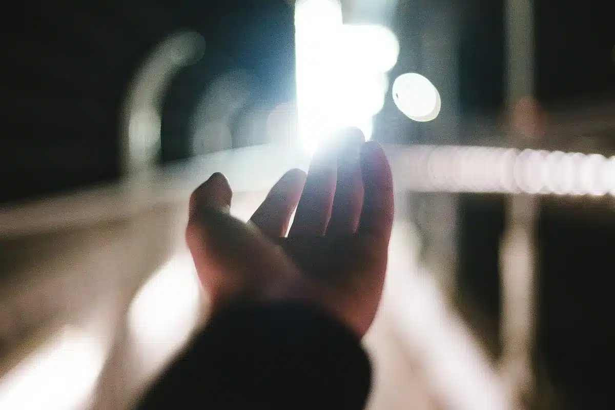 Hands holding generic casino chips with blurred slot machine lights in a casino room