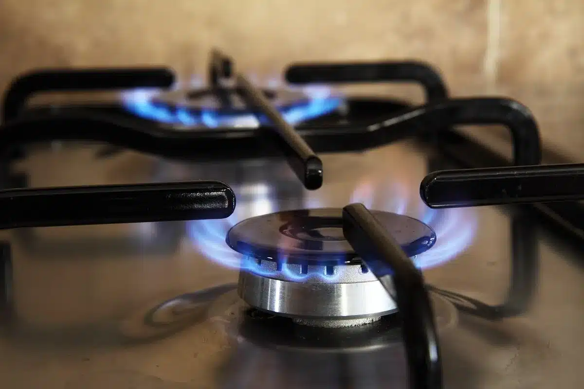 Family cooking over a small gas stove illustrating rising household energy costs