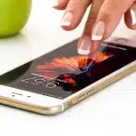 Hand holding generic spin tokens and a phone showing a spinning wheel on screen