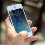 Silhouettes in a sports bar with a smartphone and betting slips on the counter