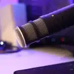 Microphone, script pages and laptop with audio waveform on a desk