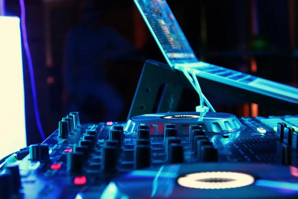Laptop showing audio waveform with headphones and notepad on a desk