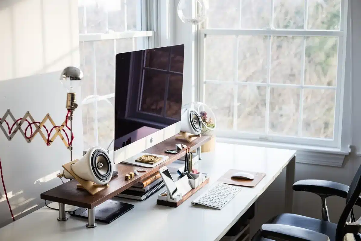 Person standing and stretching beside a desk to relieve compression
