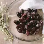 Bowl of seafood and Brazil nuts on a kitchen table with hands arranging them
