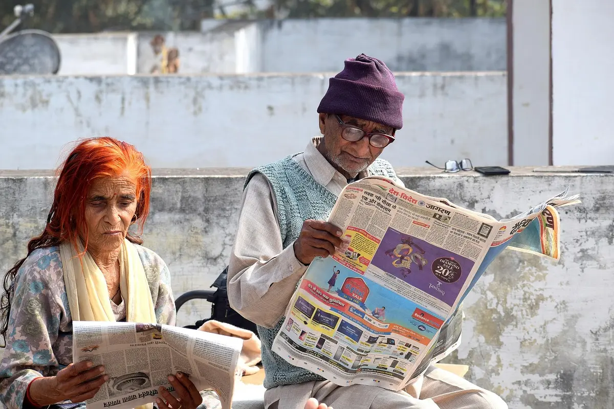 Volunteer assisting an older voter at a simulated polling station