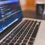 Workspace with laptop, headphones and speaker suggesting audio and software development